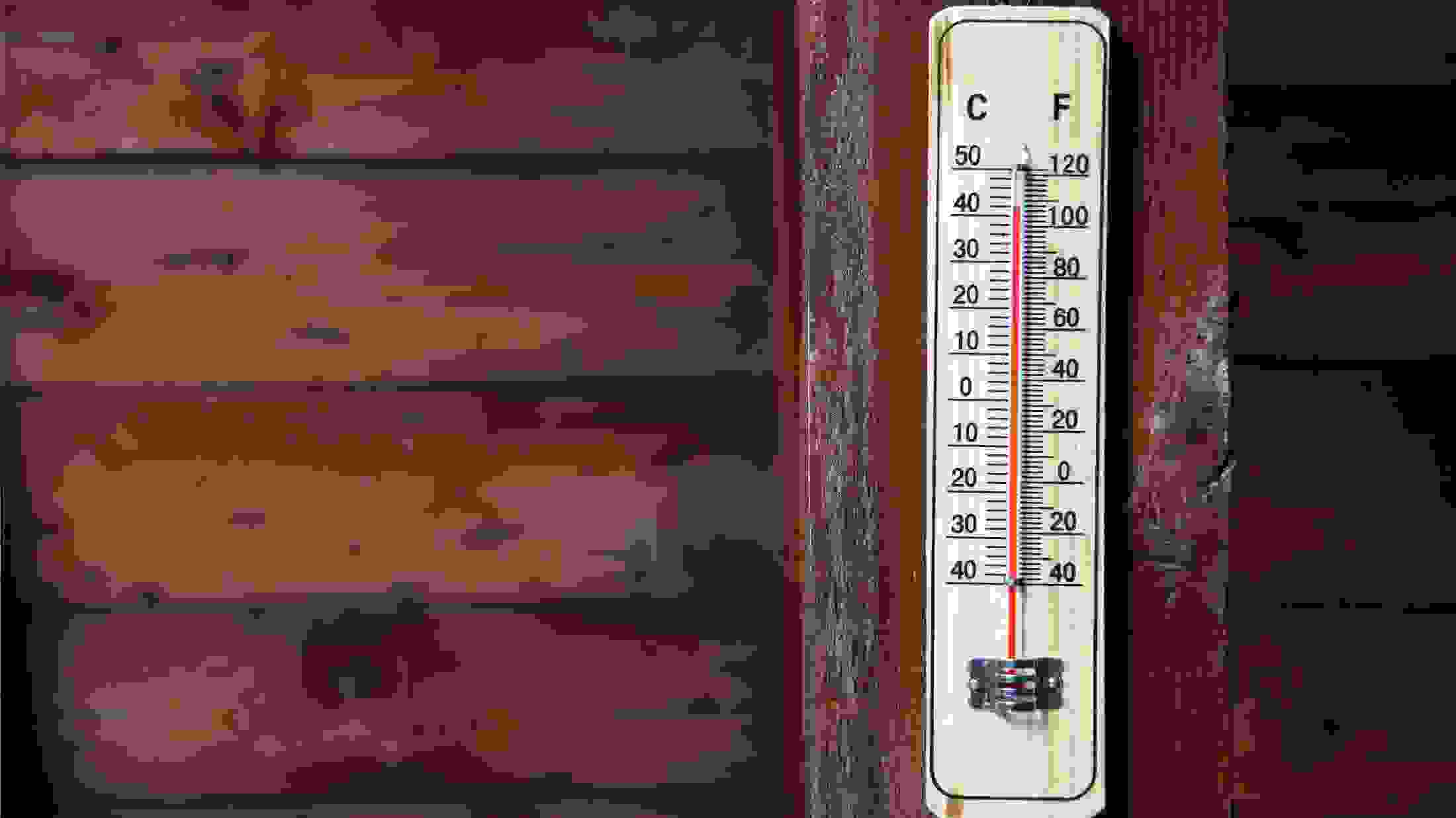 Close up of a thermostat on a wooden beam