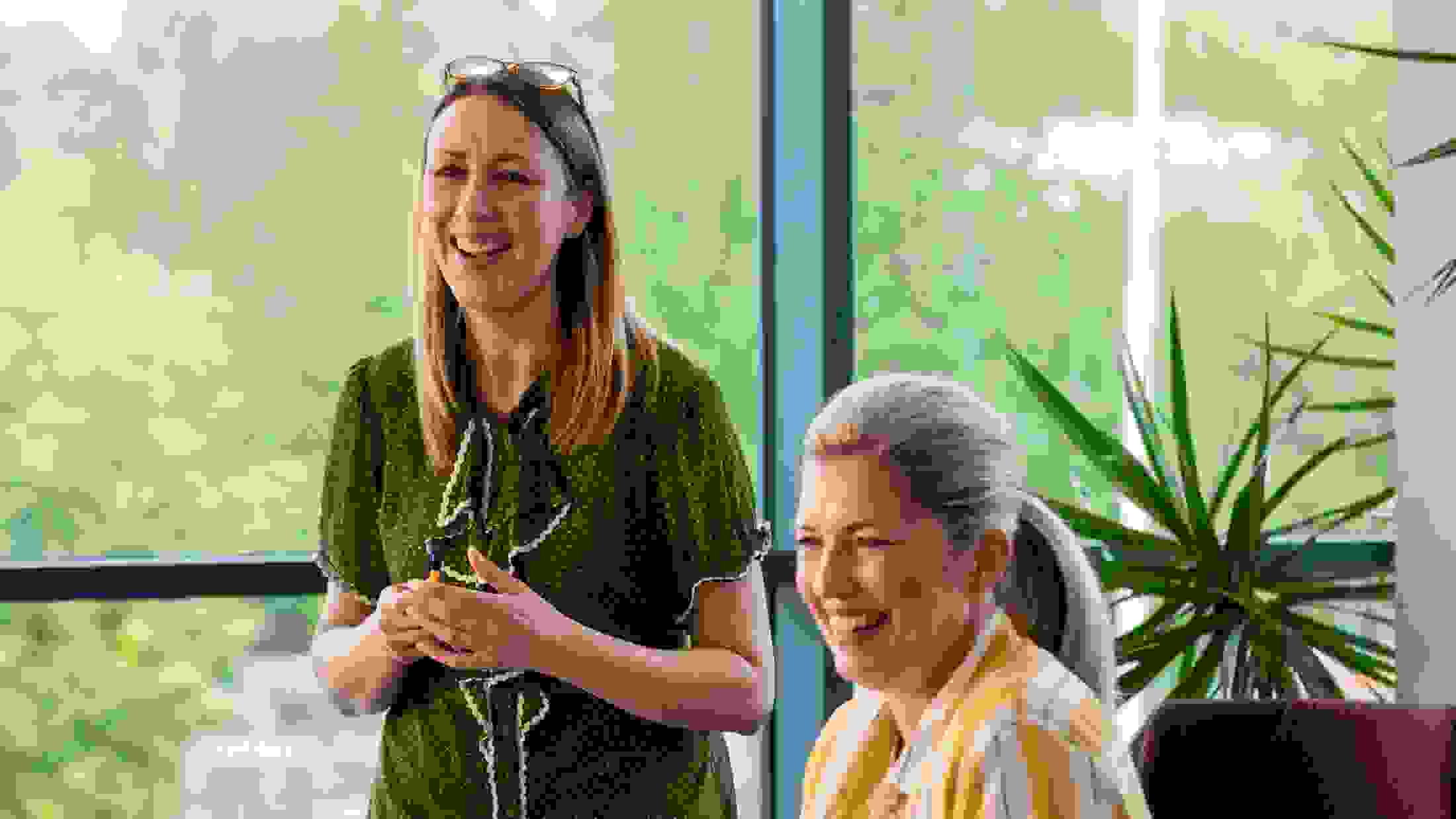 Two women laughing and enjoying listening to each others ideas in a business meeting