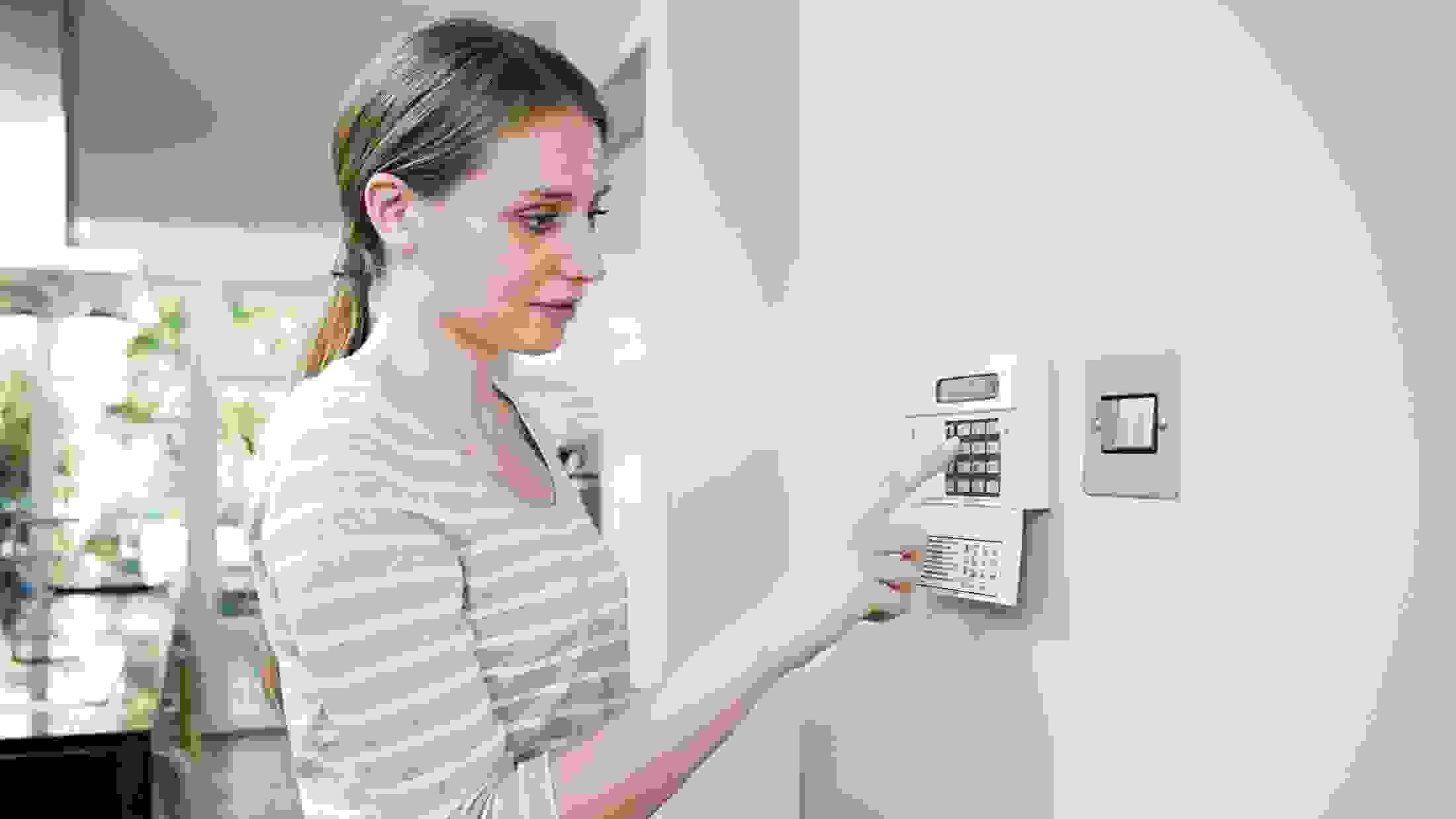 Woman setting burglar alarm via control panel.jpg