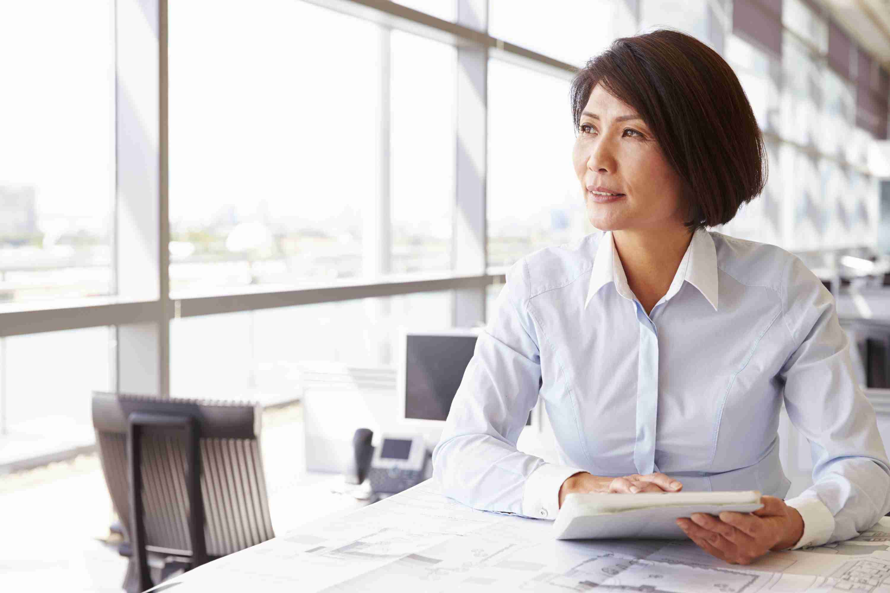 Women in office with architects plans | AXA Professional services insurance