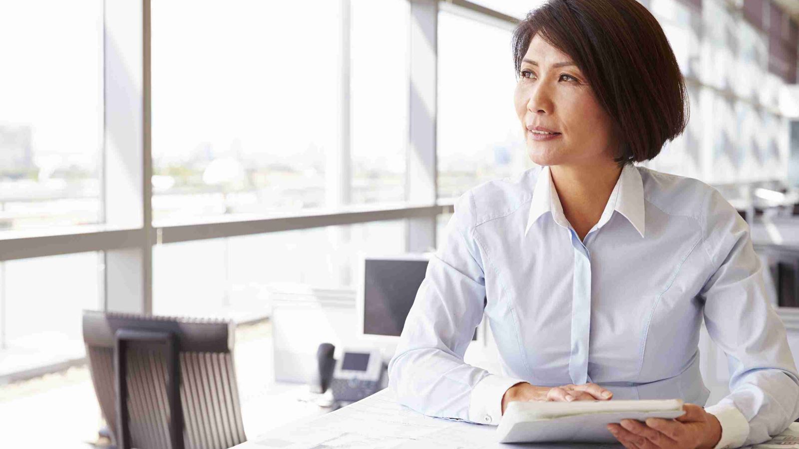 Women in office with architects plans | AXA Professional services insurance