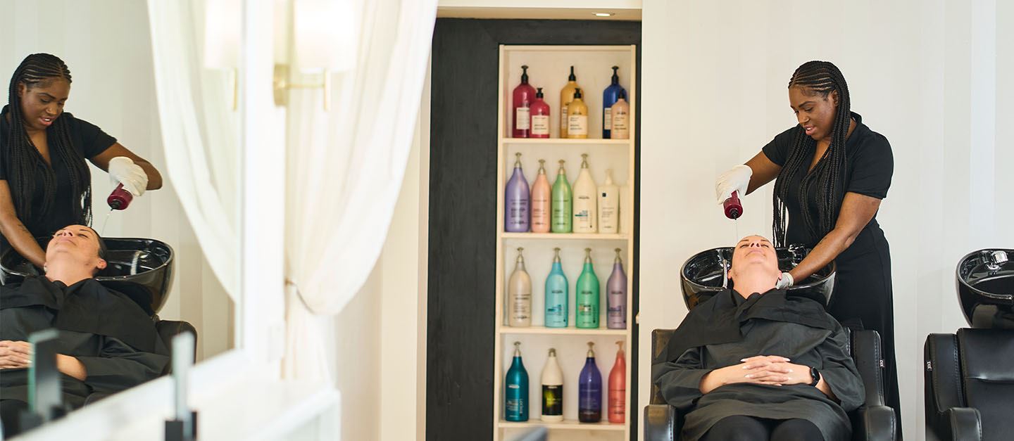 Hairdresser and AXA customer, Abigail Butler, shampooing a client's hair