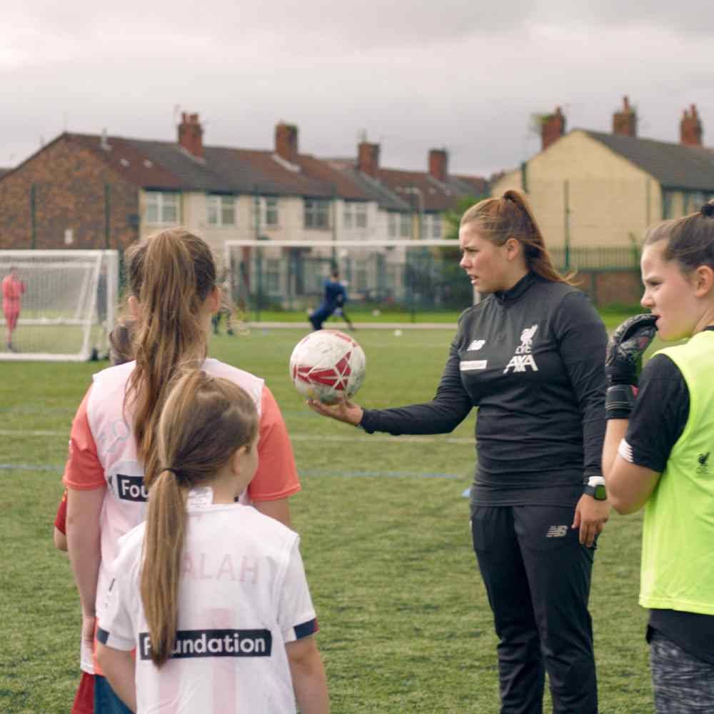 Liverpool Football Club community coach running a session with children