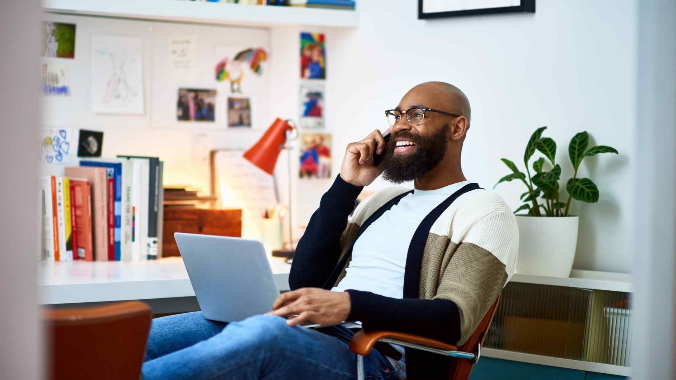 Cheerful businessman working from home on phone