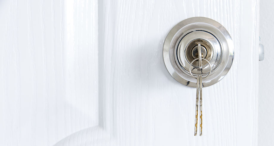 A white door with a key in the lock