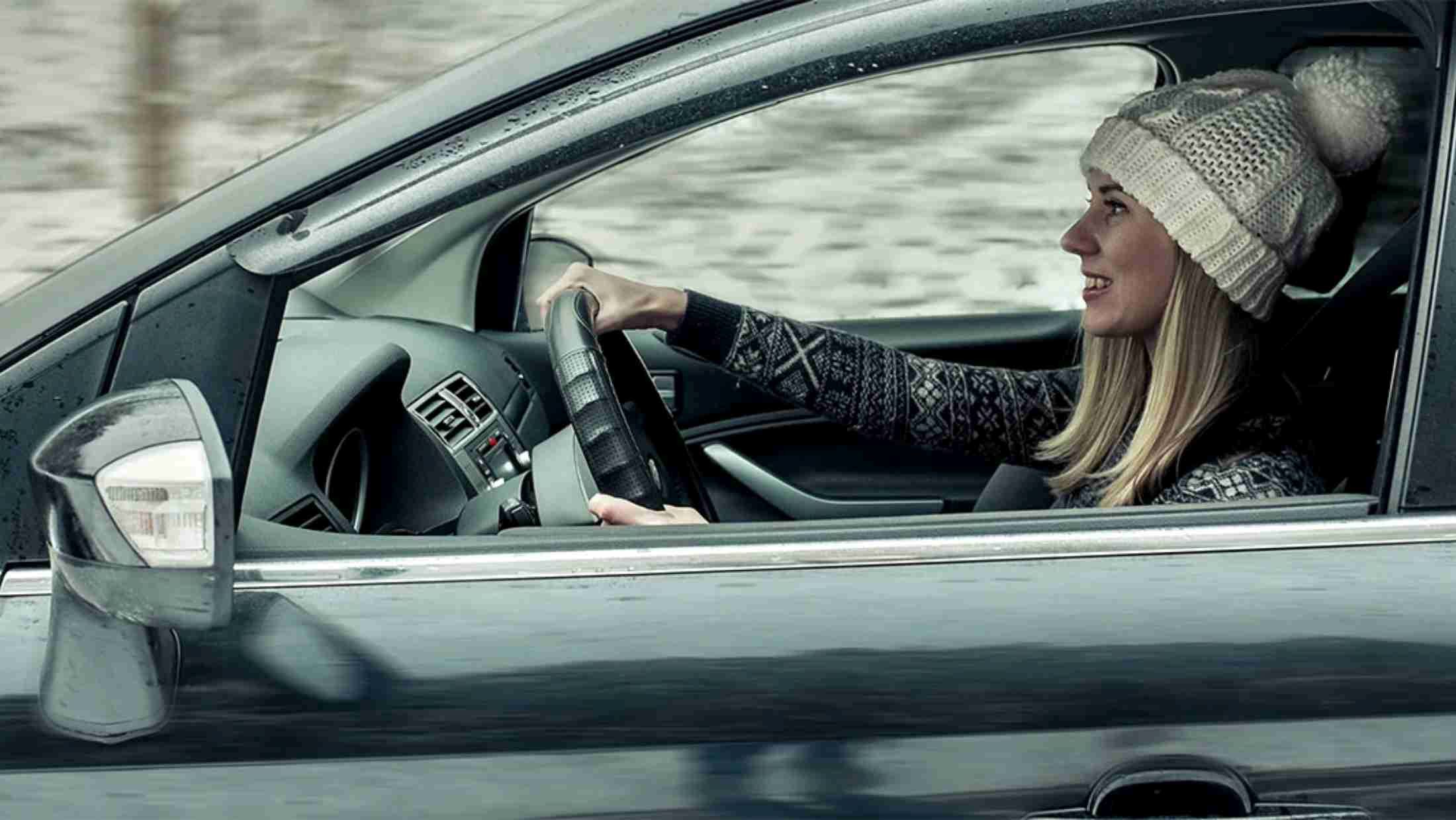 A young adult woman driving a car