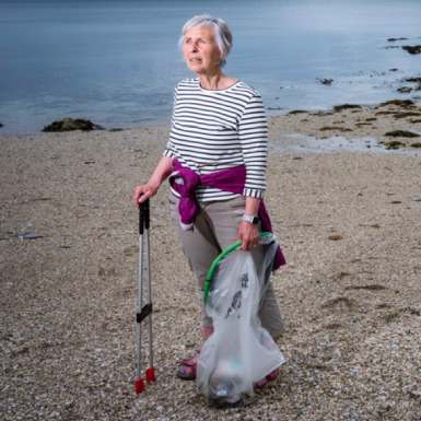 Action Nan on beach with litter picker and recycling bag