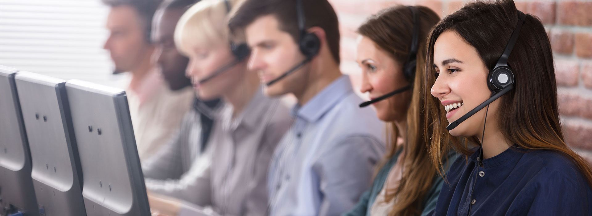 Female customer services agent with headset working in a call center