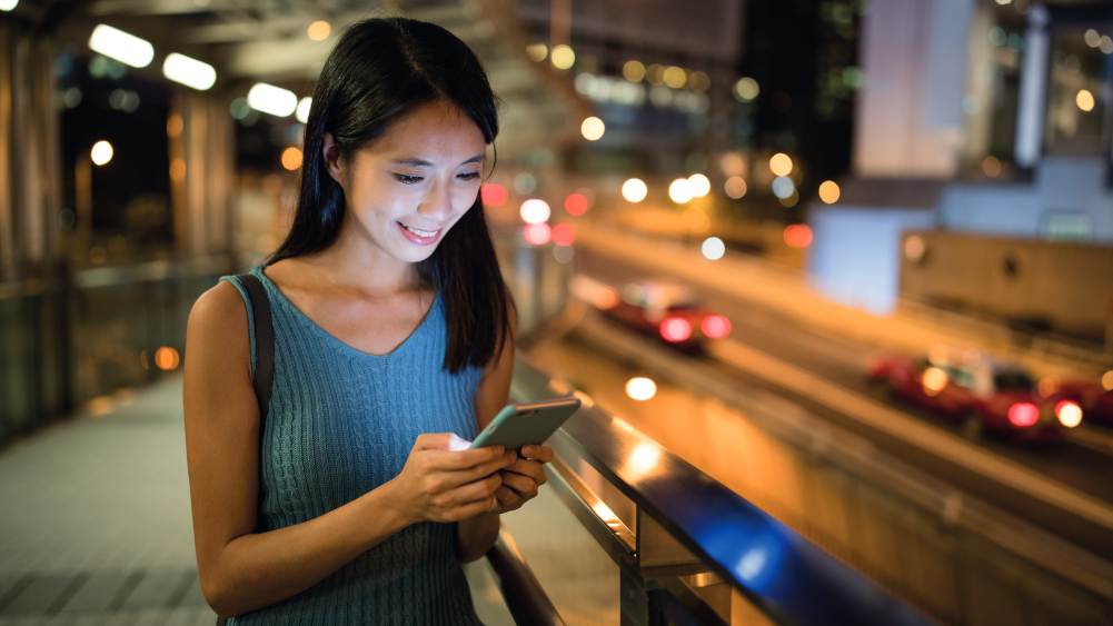 Woman looking at her phone at night