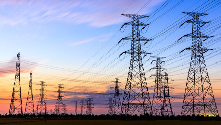 A sun rise in the background and powerlines in the foreground
