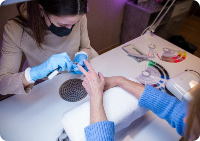 nail technician filing a clients nails
