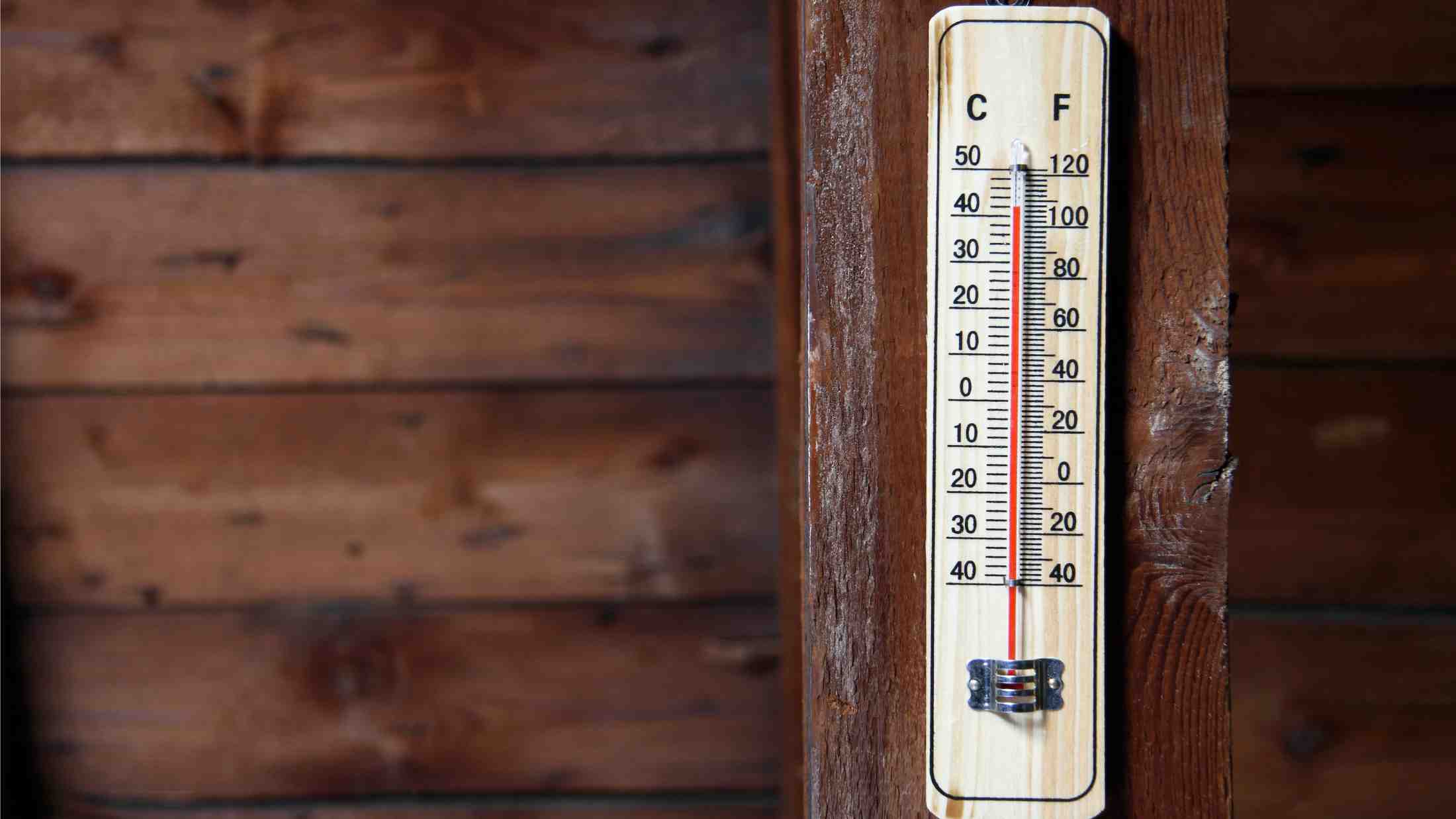 Close up of a thermostat on a wooden beam