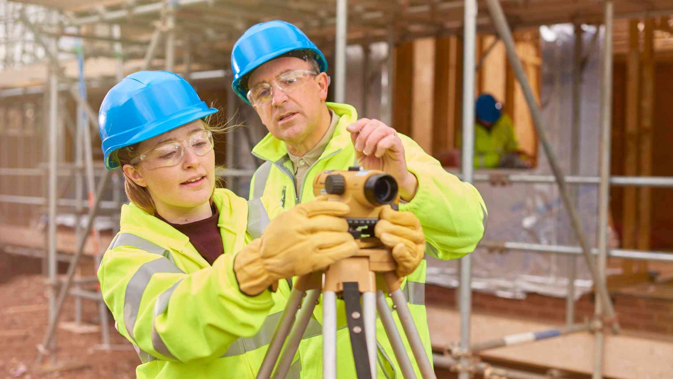 Construction worker learning how to use a builder's level
