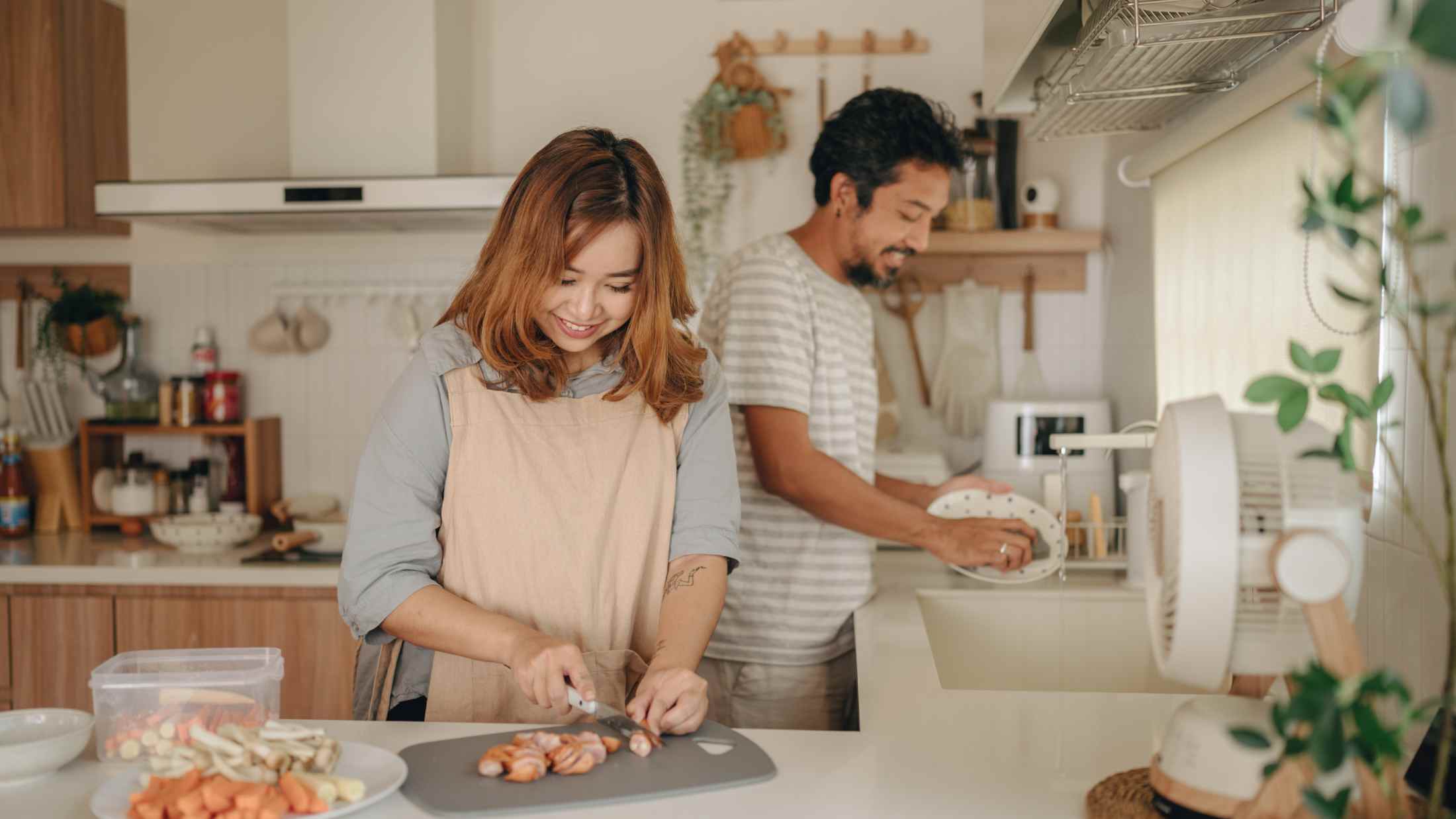 Happy affectionate couple talking while spending time in the kitchen