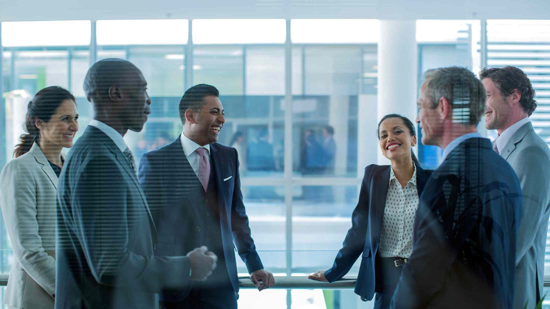 Happy multi-ethnic businesspeople discussing in office