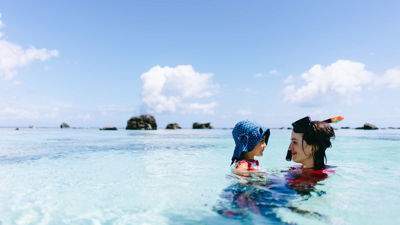 Mother and child having intimate moment in clear tropical water