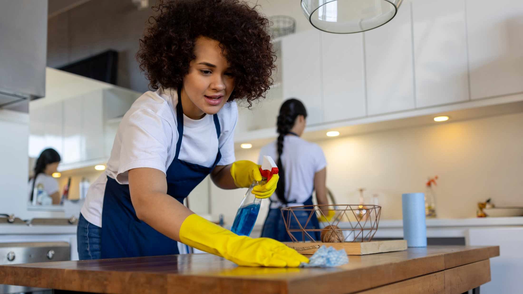 Professional cleaner cleaning a table