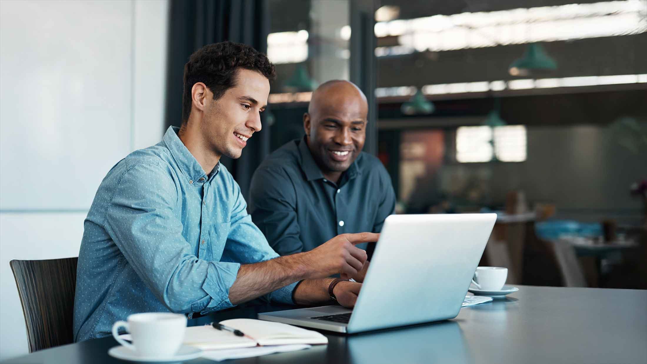 Sales manager planning branding ideas with a creative designer on a laptop