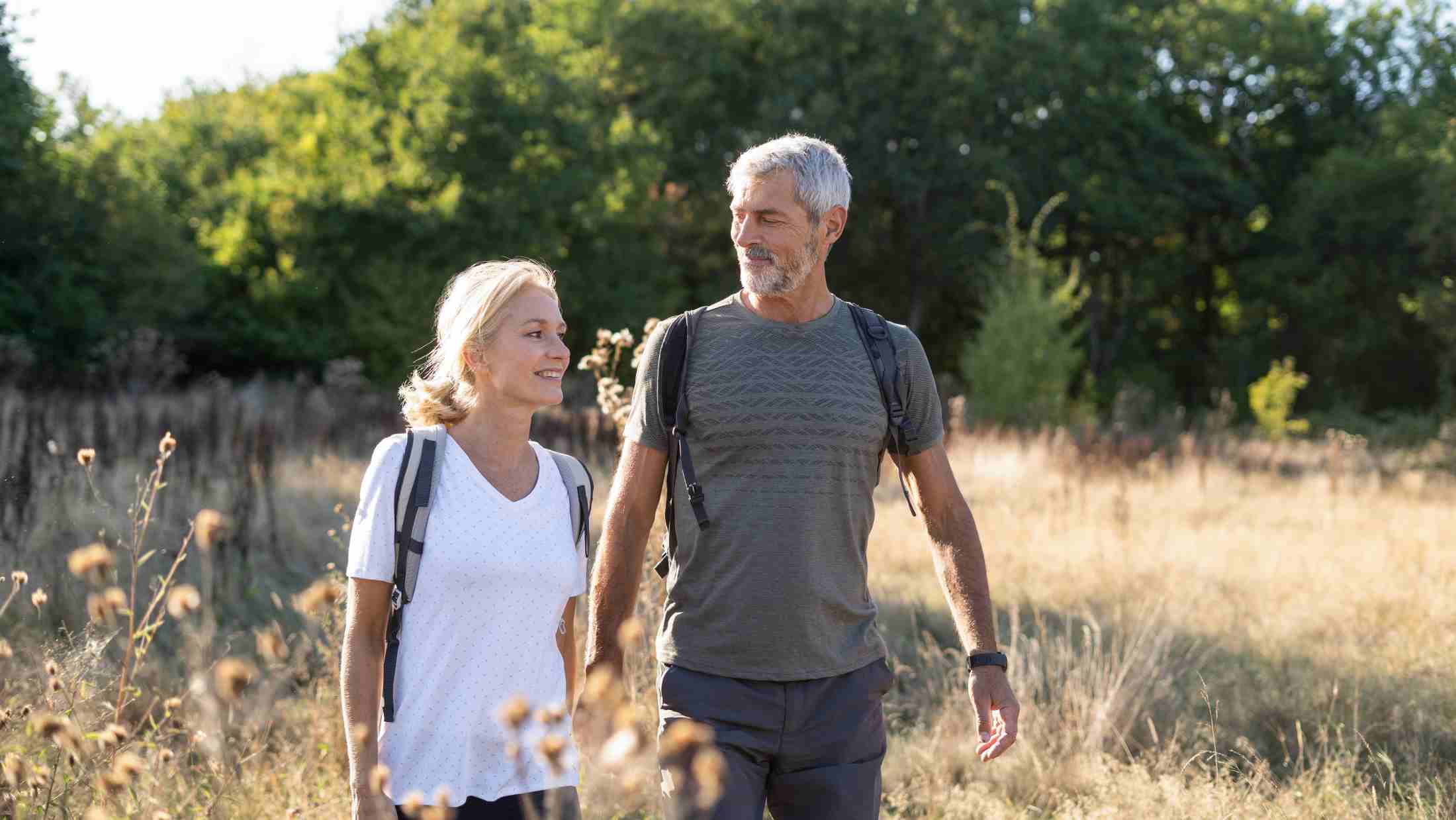 Smiling mature couple hiking in forest