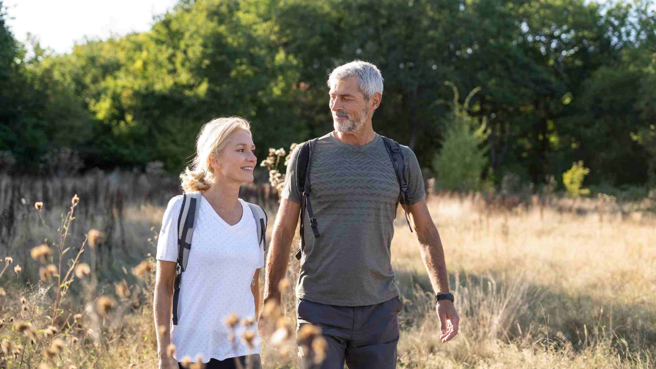 Smiling mature couple hiking in forest