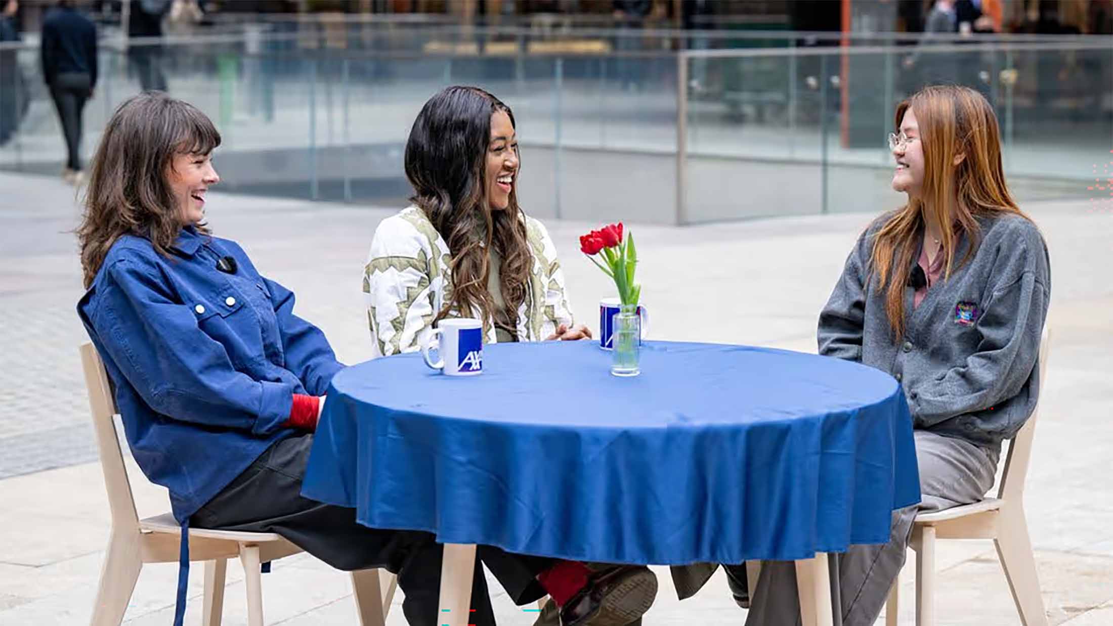 Three women sat round a table on a London street discussing a young entrepreneurs' business dreams