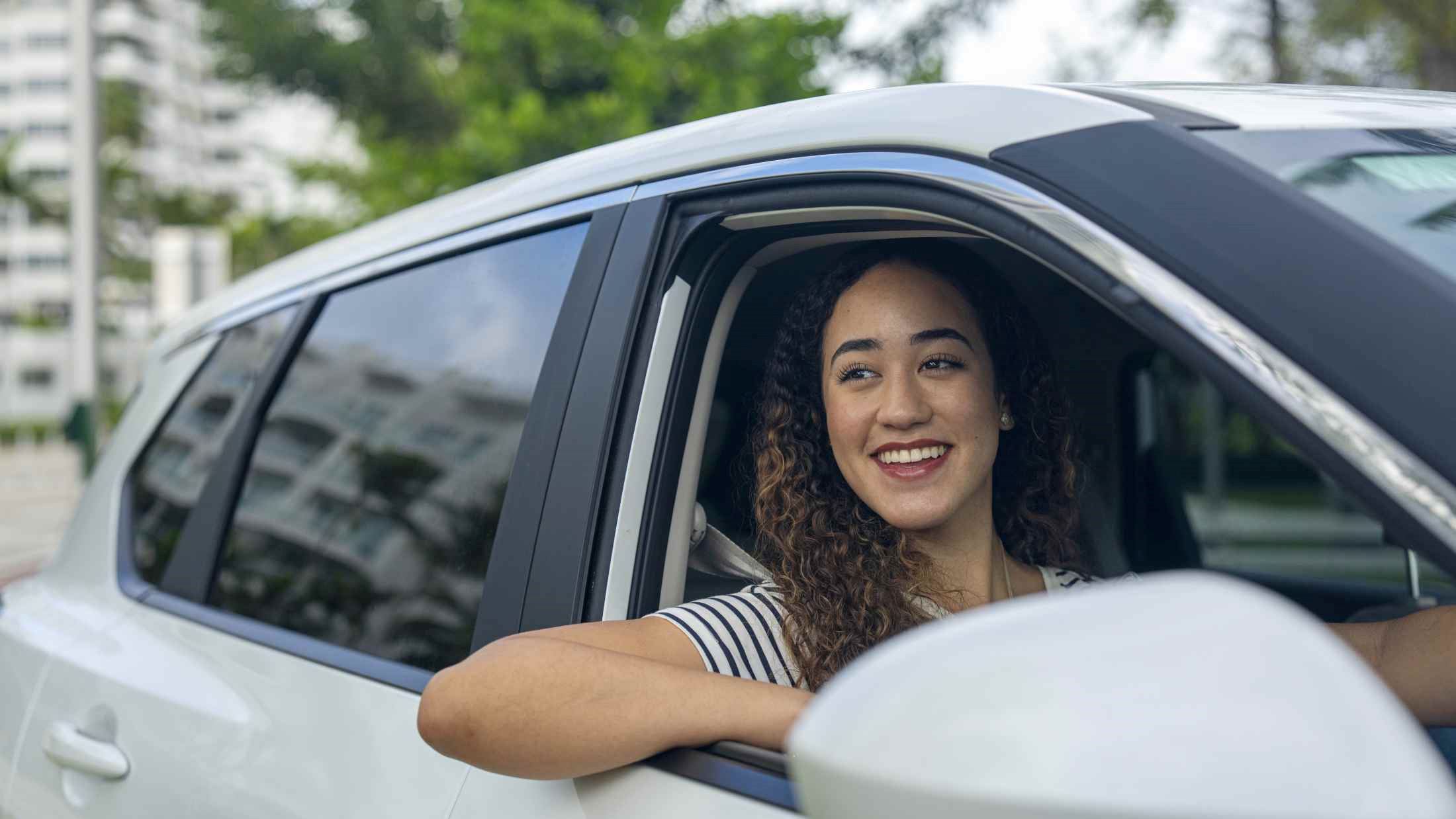 Woman looking at sights from her car while driving around with her family