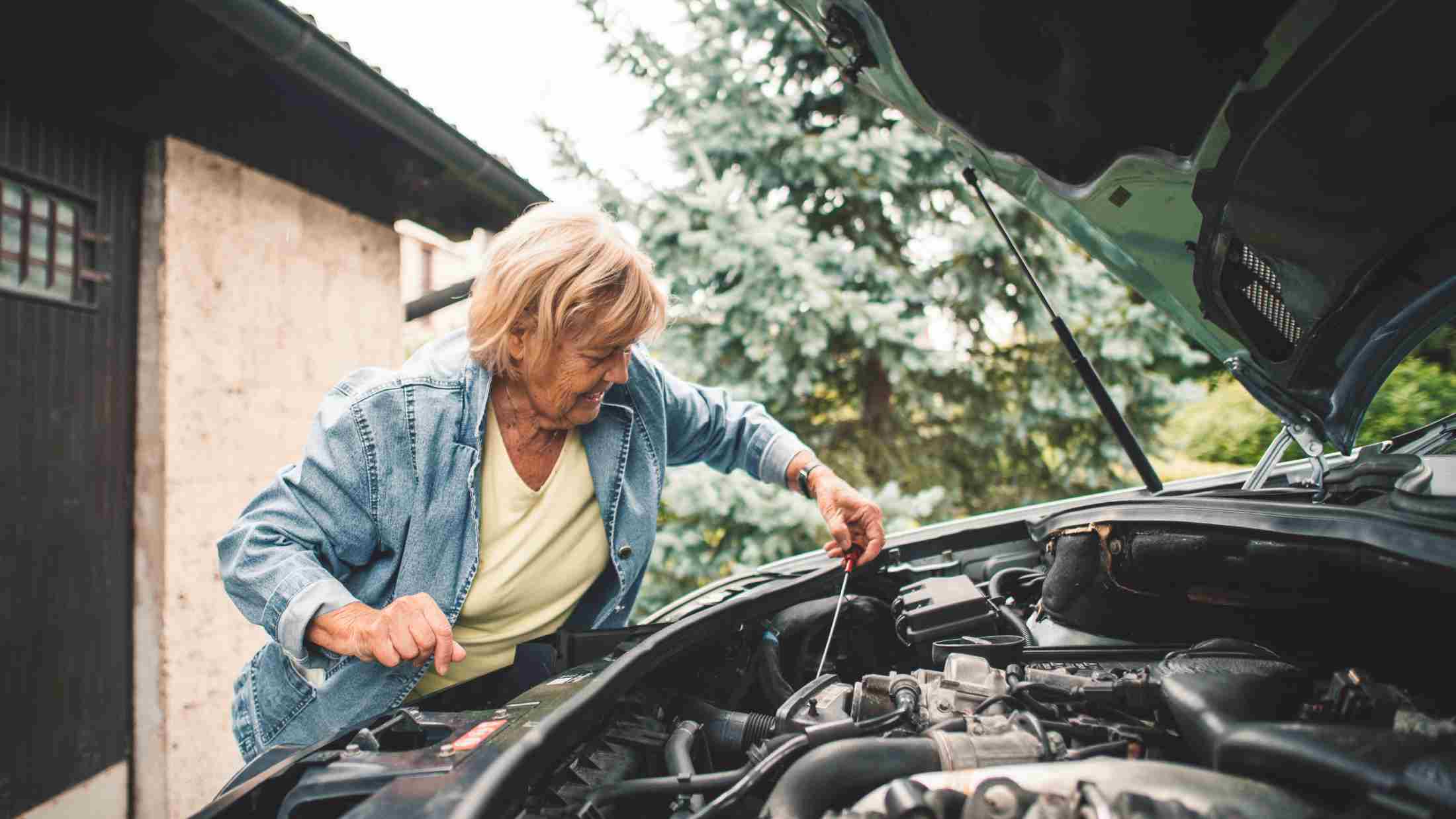 Woman trying to repair a broken down car