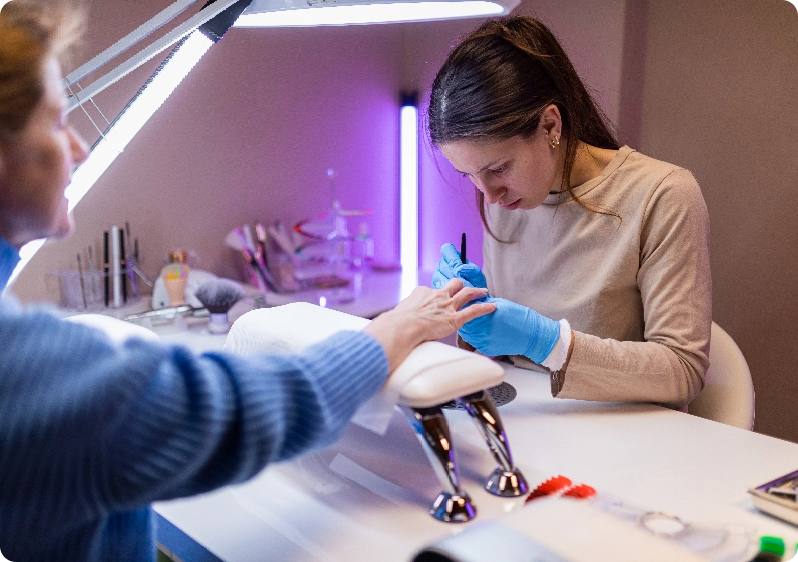 nail technician filing a clients nails