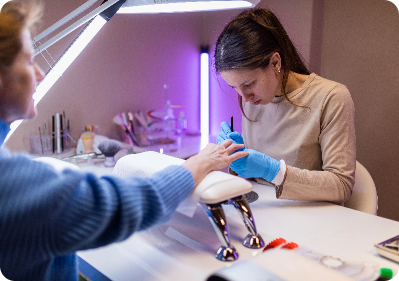 nail technician filing a clients nails