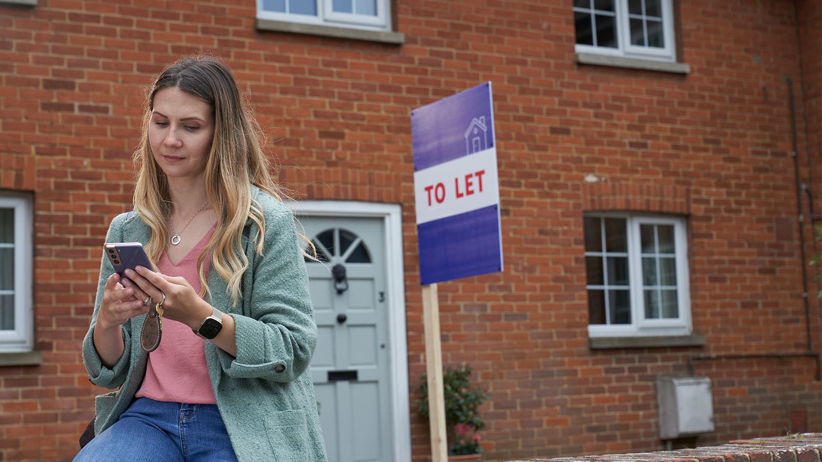 Andreea standing in front of one of her properties.