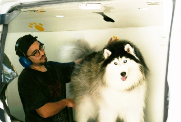 Man washing a dog outdoors