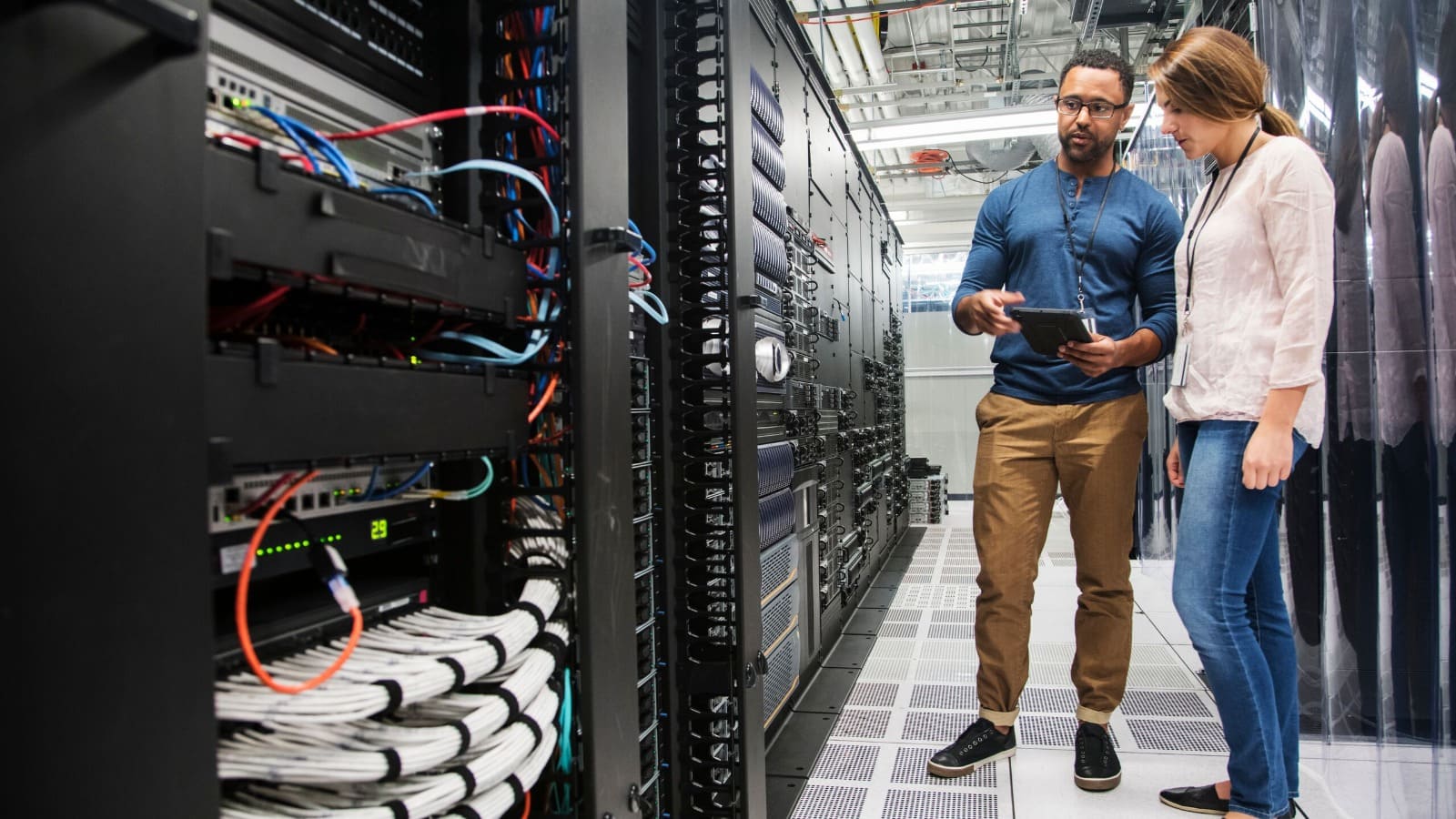 Workers in a server room maintaining systems