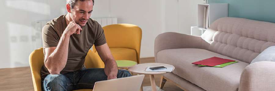 Man working on laptop in his living room