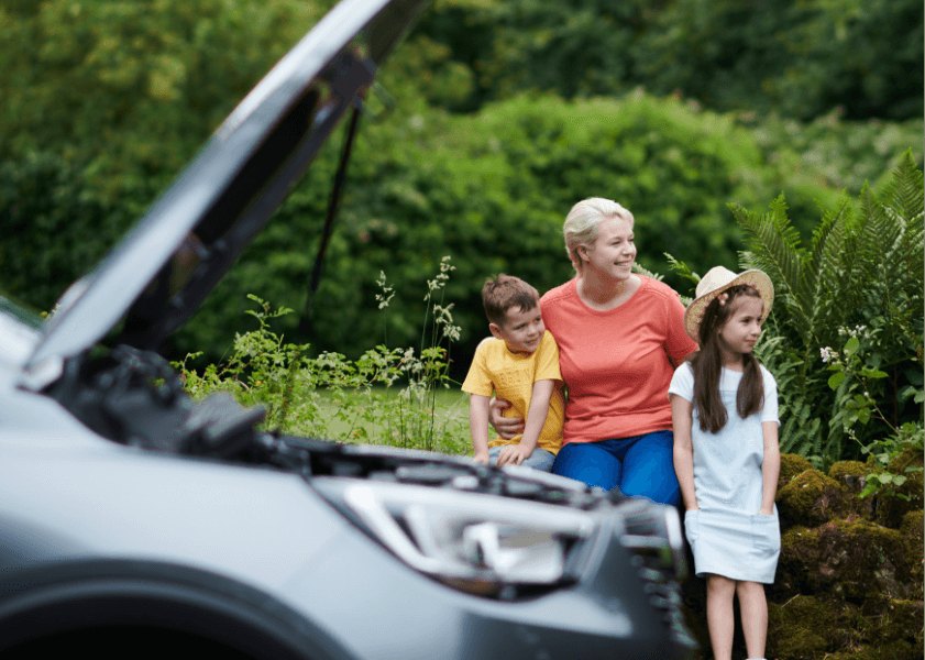 Car with bonnet up at roadside while mother and her two children wait for a mechanic to arrive