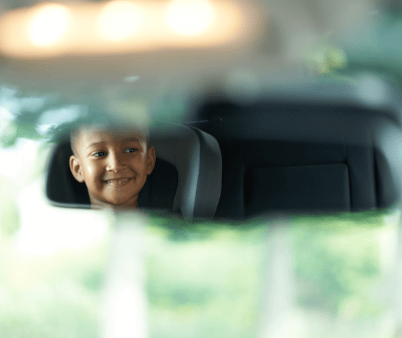 Child sat in car seat as viewed in driver's mirror