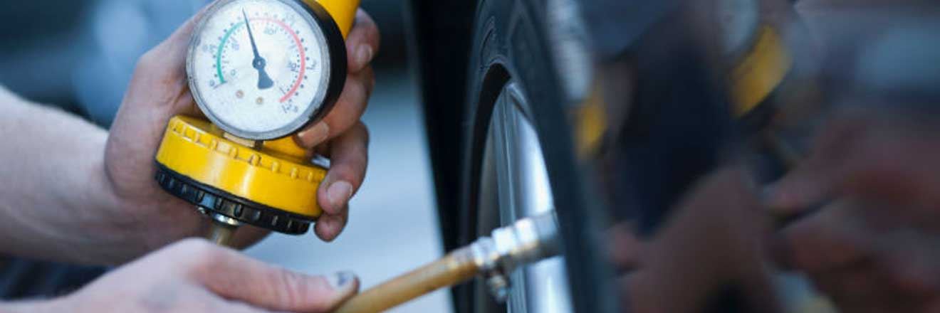 Driver checking their tyre pressure
