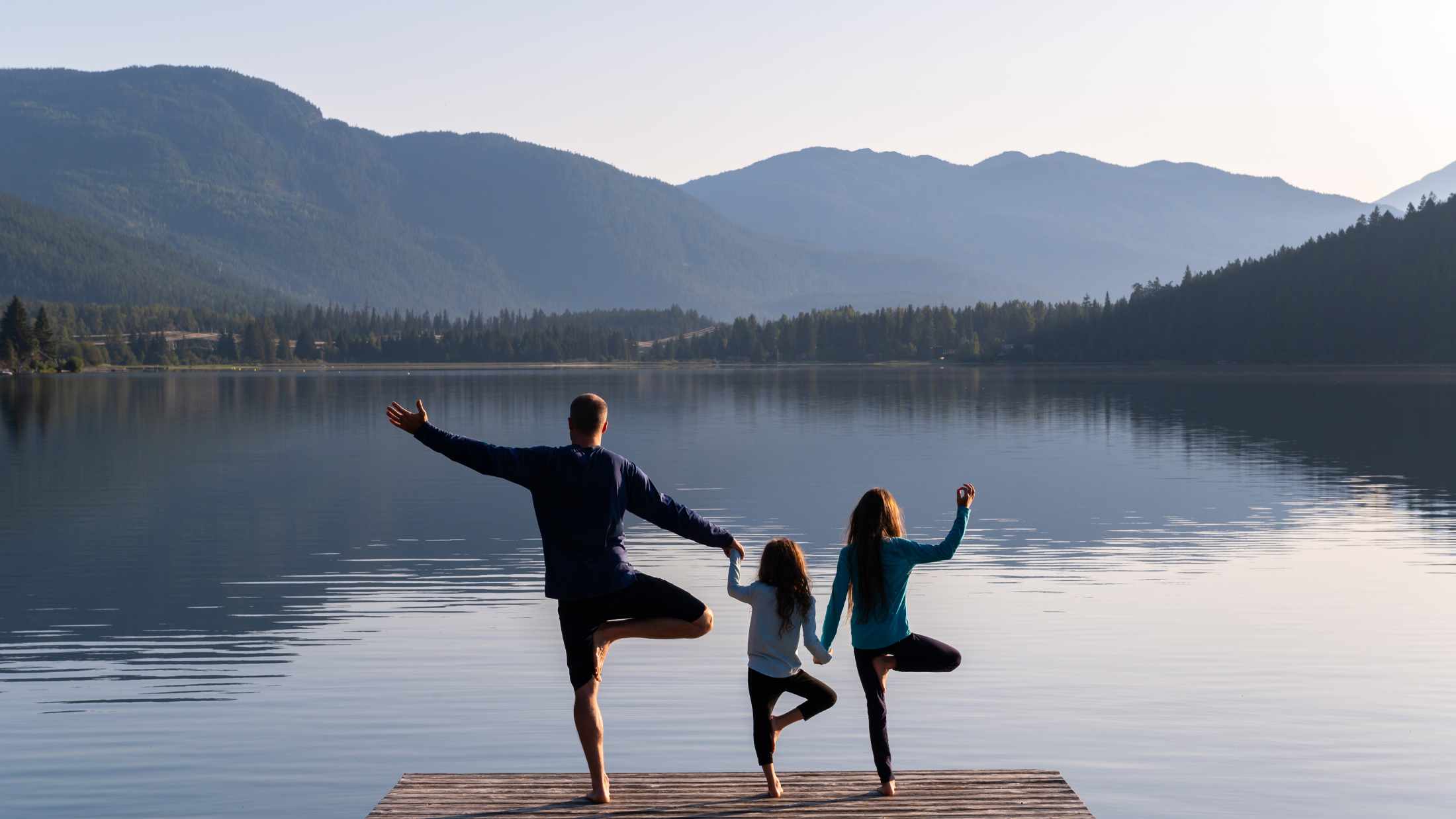 Family practising yoga outdoors. Healthy lifestyle spending time outdoors
