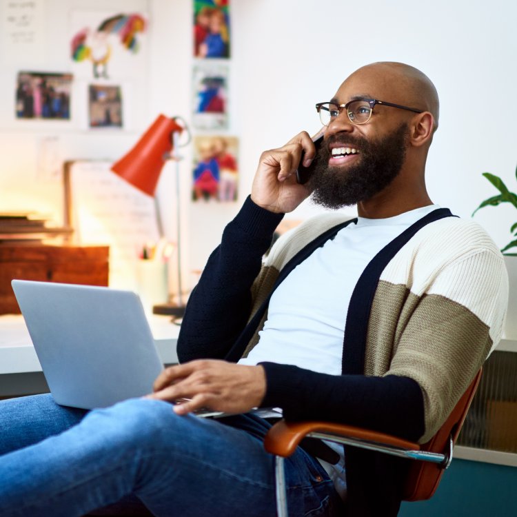 Cheerful businessman working from home on phone