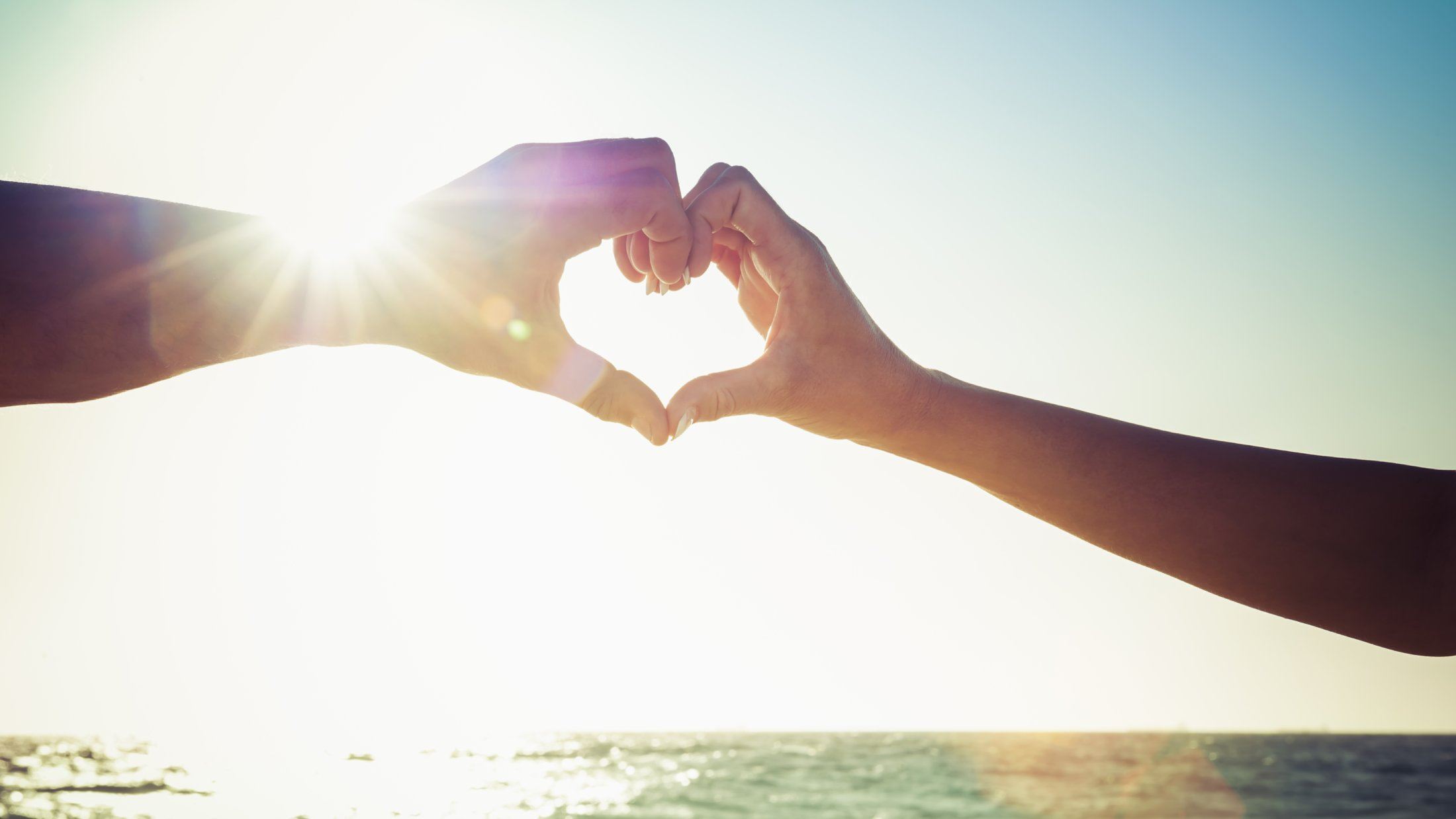 Two hands meeting to form a heart shape