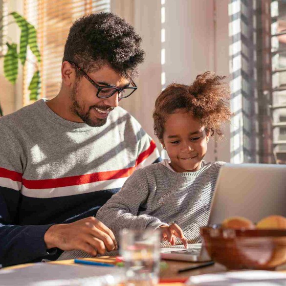 Man with child on his lap using a laptop computer