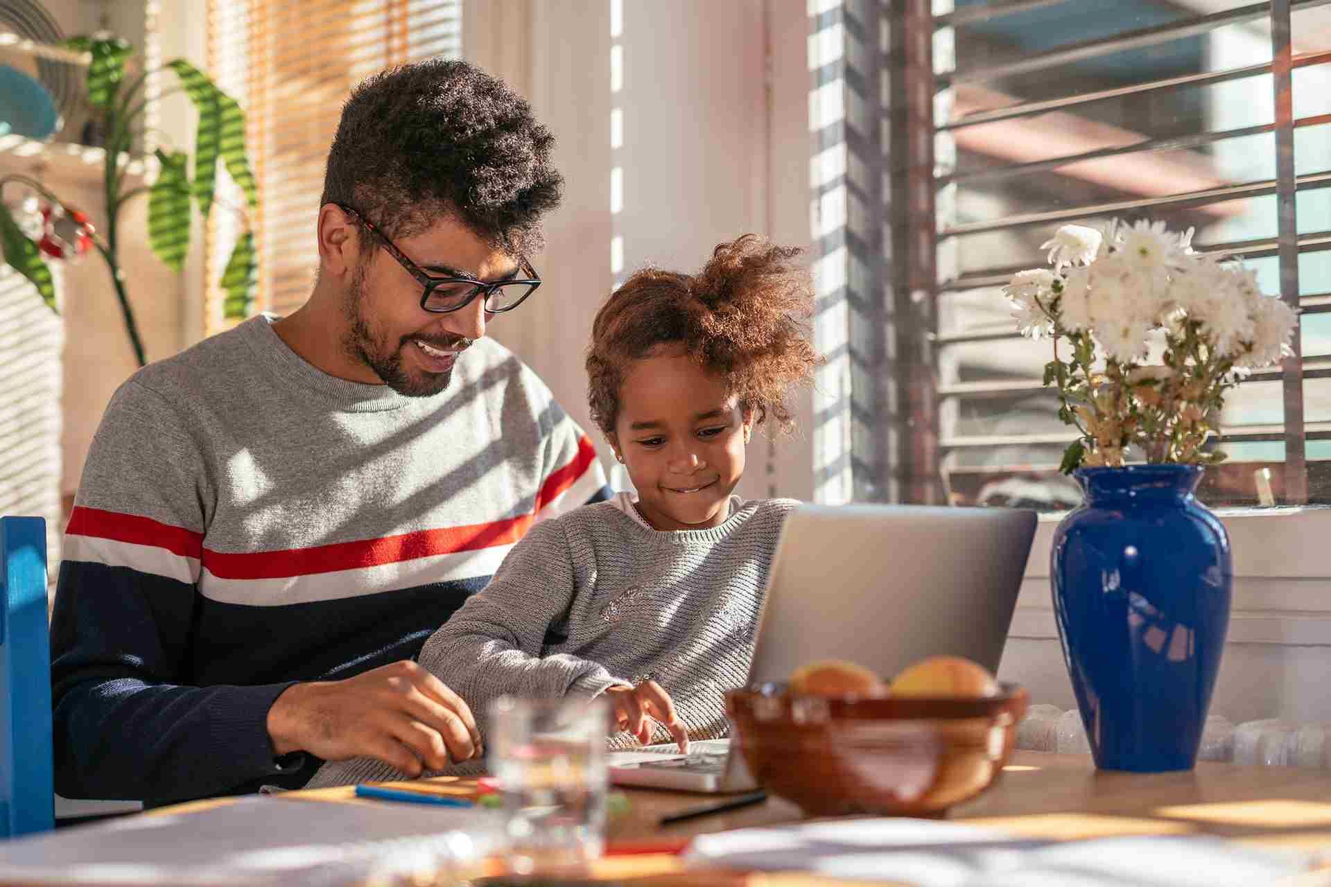Man with child on his lap using a laptop computer