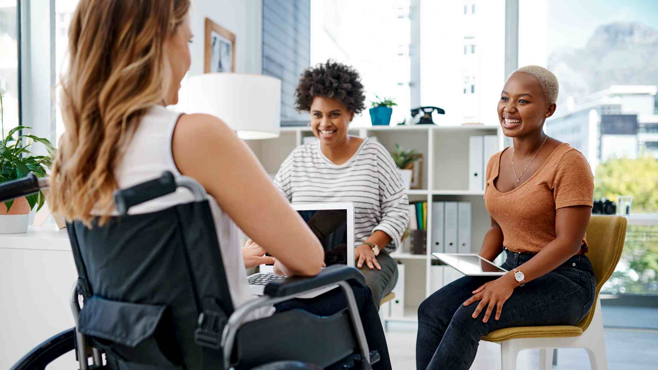 Woman in wheelchair talking to her colleagues of mixed ethnicities.jpg