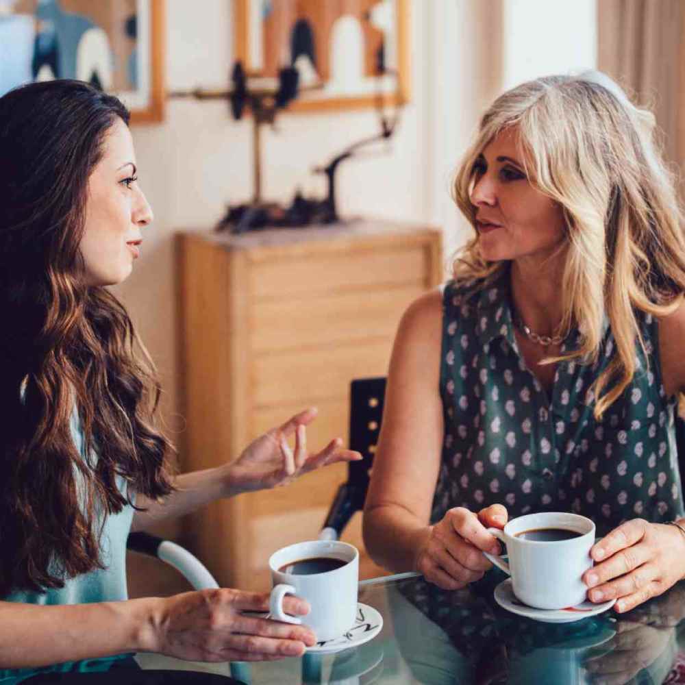 Senior mother and daughter drinking coffee together at home