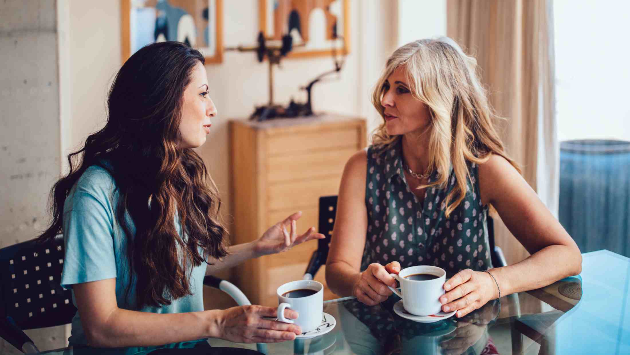 Senior mother and daughter drinking coffee together at home