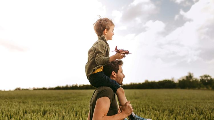 Father carrying his son on the shoulders