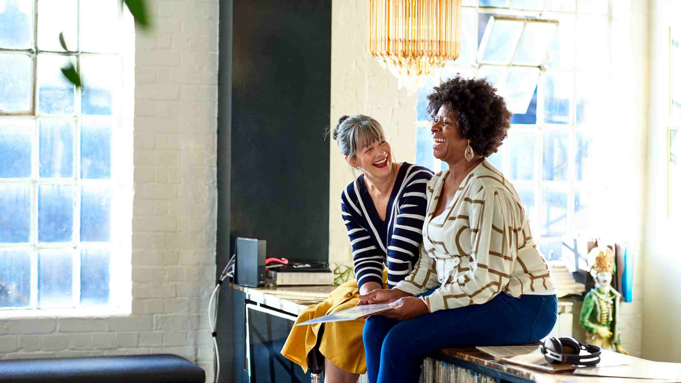Mature women laughing together in stylish loft apartment