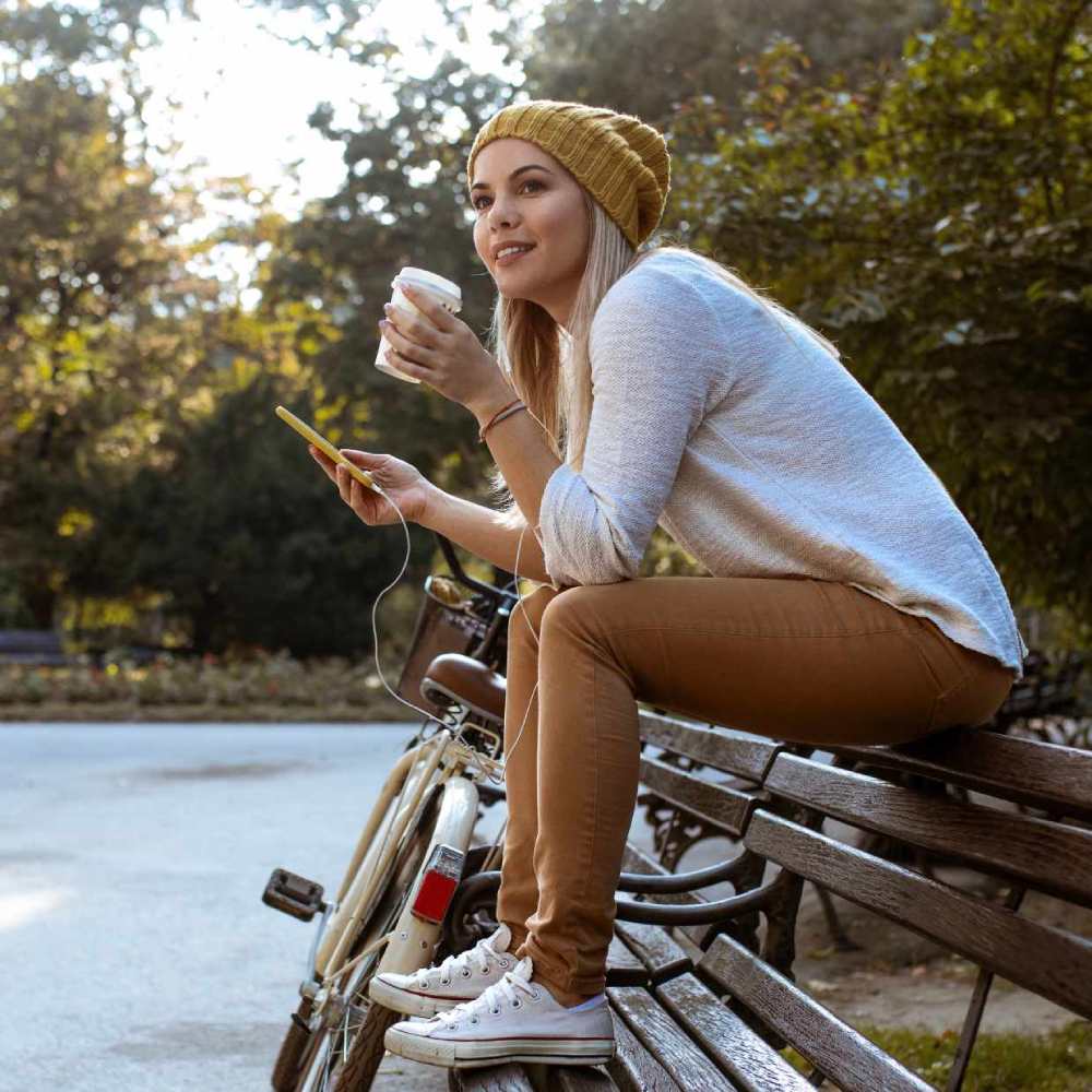Woman taking a coffee break on a park bench