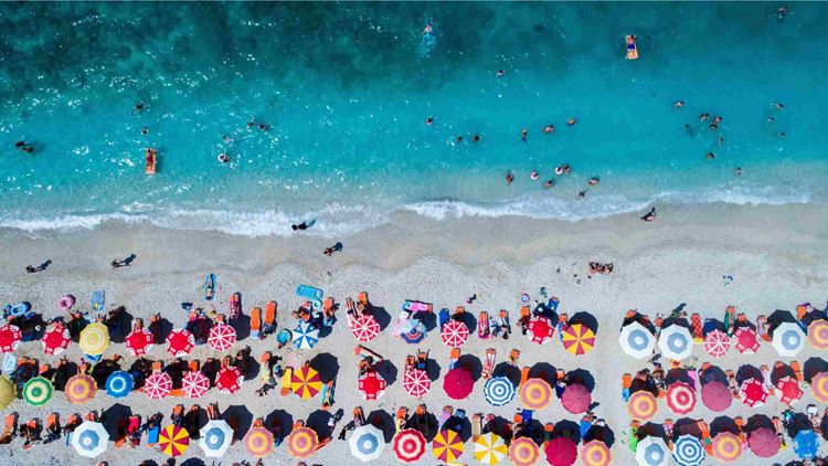 Aerial view of colorful umbrellas on shore at beach