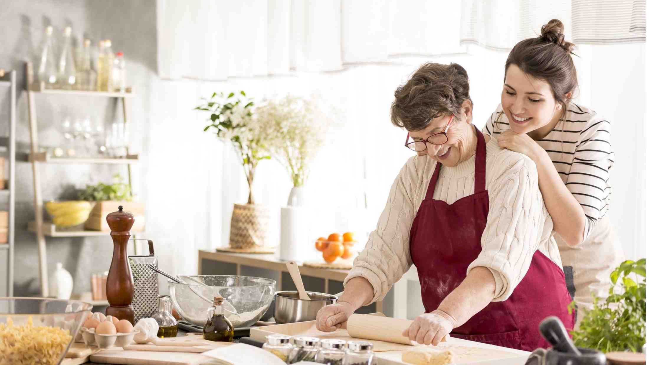 Grandmother cooking with a grand child in kitchen