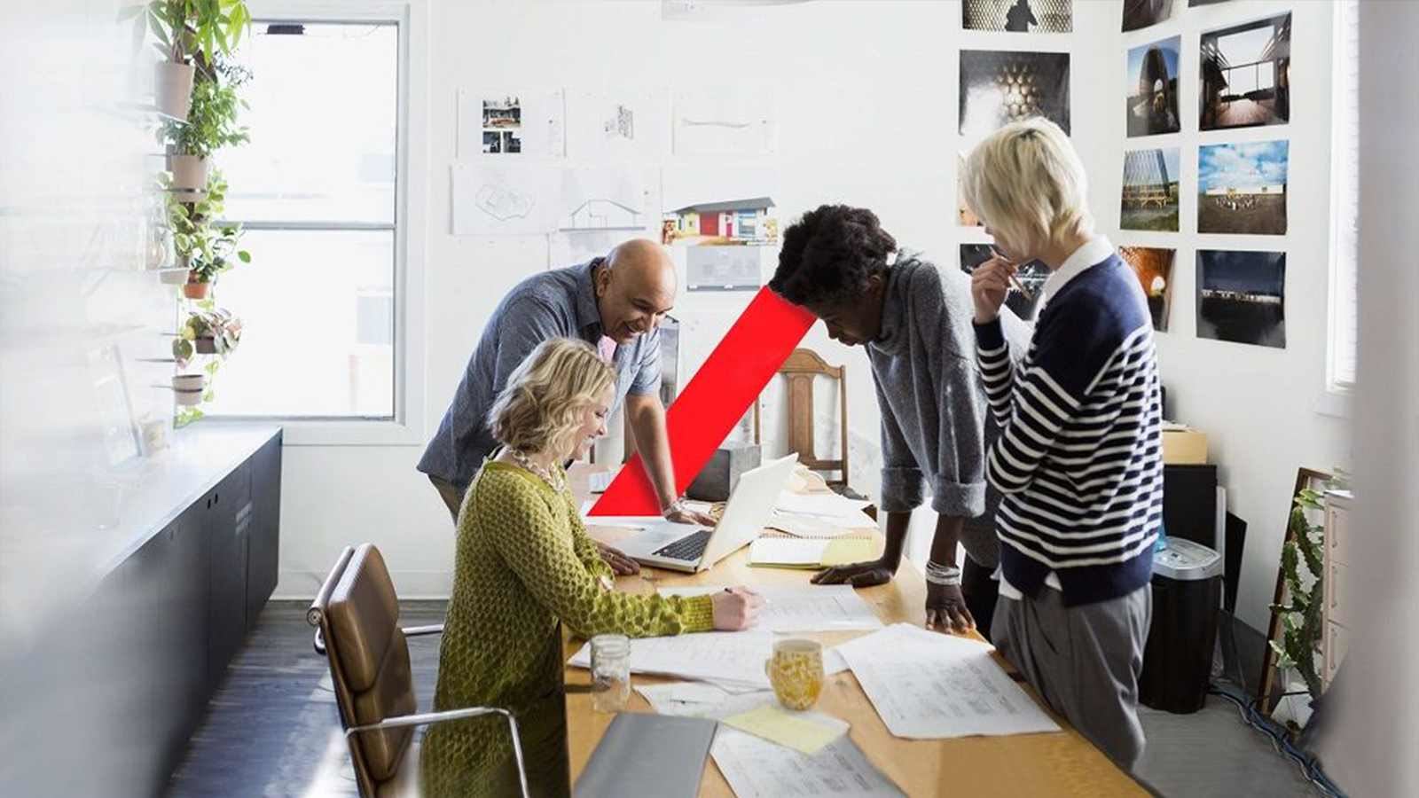 Small team in office gathered around a set of plans